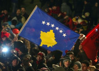 Kosovars wave the flag of independent Kosovo which was unveiled at the parliament after the declaration of independence from Serbia on February 17, 2008 in Pristina. The flag depicts a yellow outline of the newborn European nation on a dark blue field, accompanied by six stars. With yelps of joy, and tears in many eyes, Kosovo Albanians embraced independence Sunday as they poured back onto the streets of the capital Pristina that basked in wintry sunshine.  AFP PHOTO/ARMEND NIMANI (Photo credit should read Armend Nimani/AFP/Getty Images)