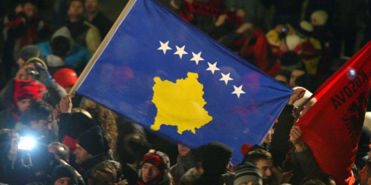 Kosovars wave the flag of independent Kosovo which was unveiled at the parliament after the declaration of independence from Serbia on February 17, 2008 in Pristina. The flag depicts a yellow outline of the newborn European nation on a dark blue field, accompanied by six stars. With yelps of joy, and tears in many eyes, Kosovo Albanians embraced independence Sunday as they poured back onto the streets of the capital Pristina that basked in wintry sunshine.  AFP PHOTO/ARMEND NIMANI (Photo credit should read Armend Nimani/AFP/Getty Images)