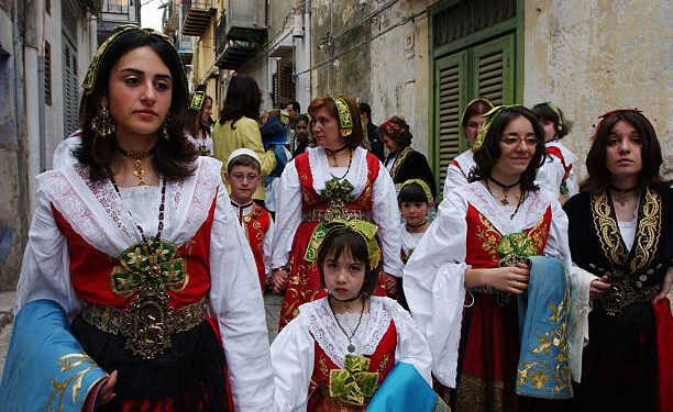 PIANA DEGLI ALBANESI, ITALY - APRIL 11:  Arbereshe girls dressed in their traditional costumes attends the Procession Of The Misteri after Easter Sunday Holy Mass April 11, 2004 in Piana degli Albanesi, Sicily, Italy. Piana degli Albanesi, with approximately 6,000 Arberereshe residents, is the most important of the five Albanian settlements in Sicily. The Arberereshe are the decendents of Albanians who immigrated to Sicily during the 15th century after the Turkish invasion in Albania. All the residents still keep their traditions and speak Arberes which will soon be taught in schools. On Holy Easter Sunday after Mass, the girls continue the Greek-byzantine rite where girls, dressed in their traditional Arbereshe costumes, walk in procession along the streets of the village called the Procession Of The Misteri where they deliver consecrated red eggs.  (Photo by Marco Di Lauro/Getty Images)