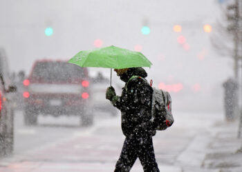 DENVER, CO - FEBRUARY 16 : A pedestrian across Broadway near the corner of 16th st. in Denver, Colorado on Wednesday, February 16, 2022. A winter storm warning is posted for the Denver metro area through 5 a.m. Thursday with up to 8 inches of snow possible in parts of the metro area and up to 12 inches in areas of the foothills.(Photo by Hyoung Chang/MediaNews Group/The Denver Post via Getty Images)