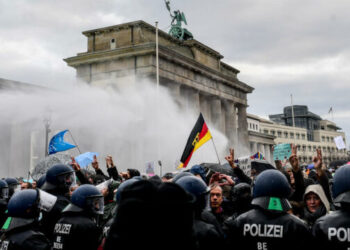 epaselect epa08827850 Riot police uses a water cannon to break up the demonstration against German coronavirus restrictions, near the Brandenburg Gate in Berlin, Germany, 18 November 2020. While German interior minister prohibited demonstrations around the Reichstag building during the parliamentary Bundestag session, people gathered to protest against government-imposed semi-lockdown measures aimed at curbing the spread of the coronavirus pandemic. Since 02 November, all restaurants, bars, cultural venues, fitness studious, cinemas and sports halls are forced to close for four weeks as a lockdown measure to rein in skyrocketing coronavirus infection rates.  EPA-EFE/FILIP SINGER
